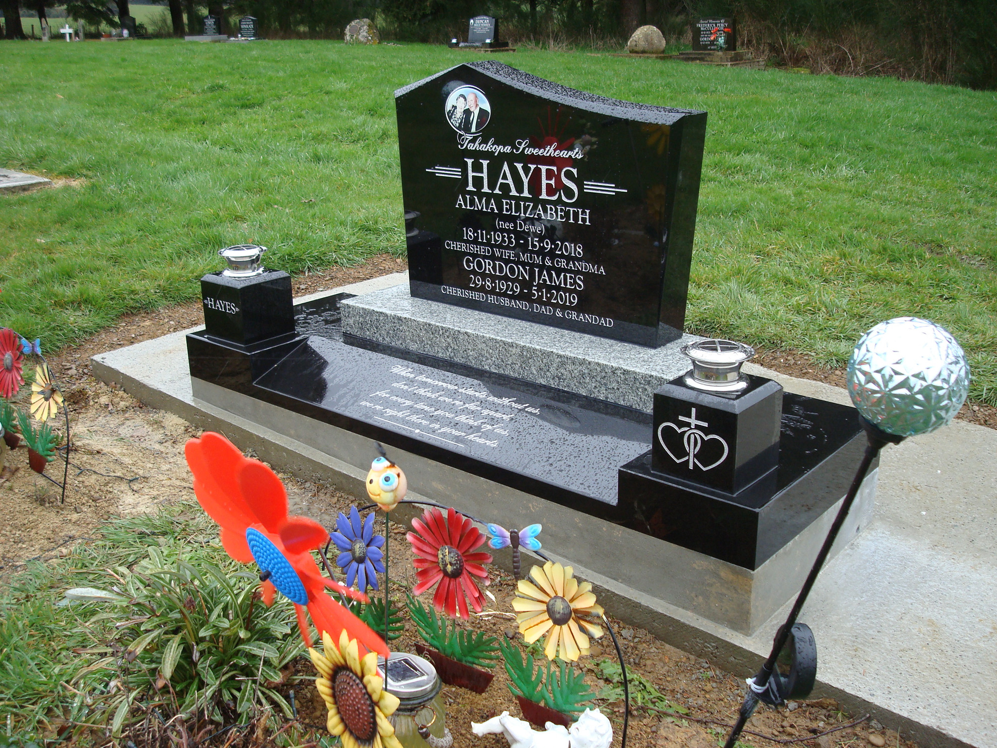 Black granite plot with kerbing, vases and ornaments, freshly tended